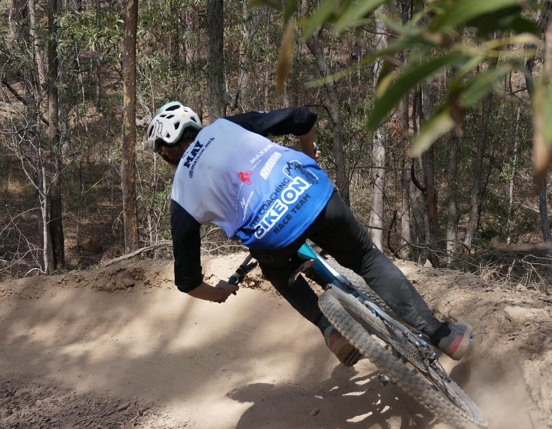 Bike On coach in uniform railing a dirt berm on a Sunshine Coast mountain bike trail