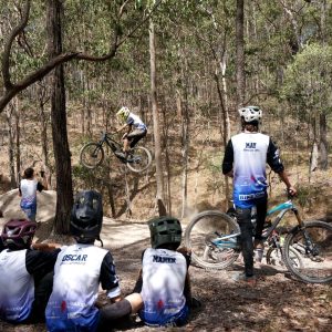 Advanced Development riders watching a teammate hit a jump during a coaching session
