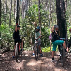 Group of young riders with their bikes on a forest trail