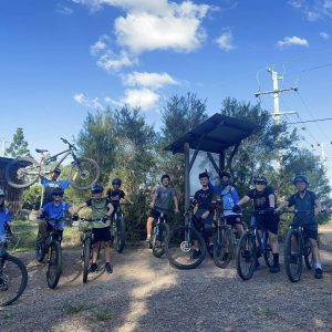 Group of kids with their bikes at a trailhead on a sunny day