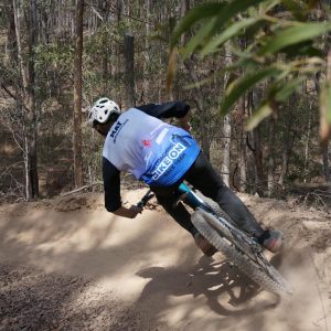 Rider in a Bike On race team jersey carving a berm